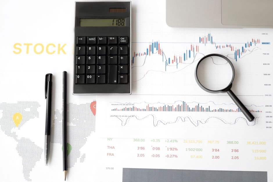 Loupe posée sur des graphiques boursiers, symbole de l'analyse critique d'un backtest