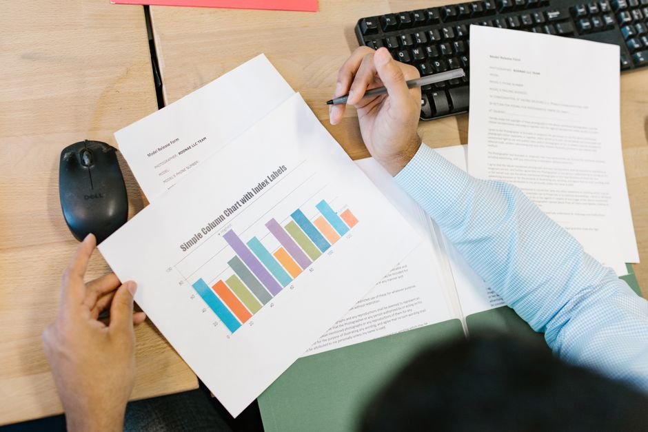 Analyst comparing printed performance reports with bar charts